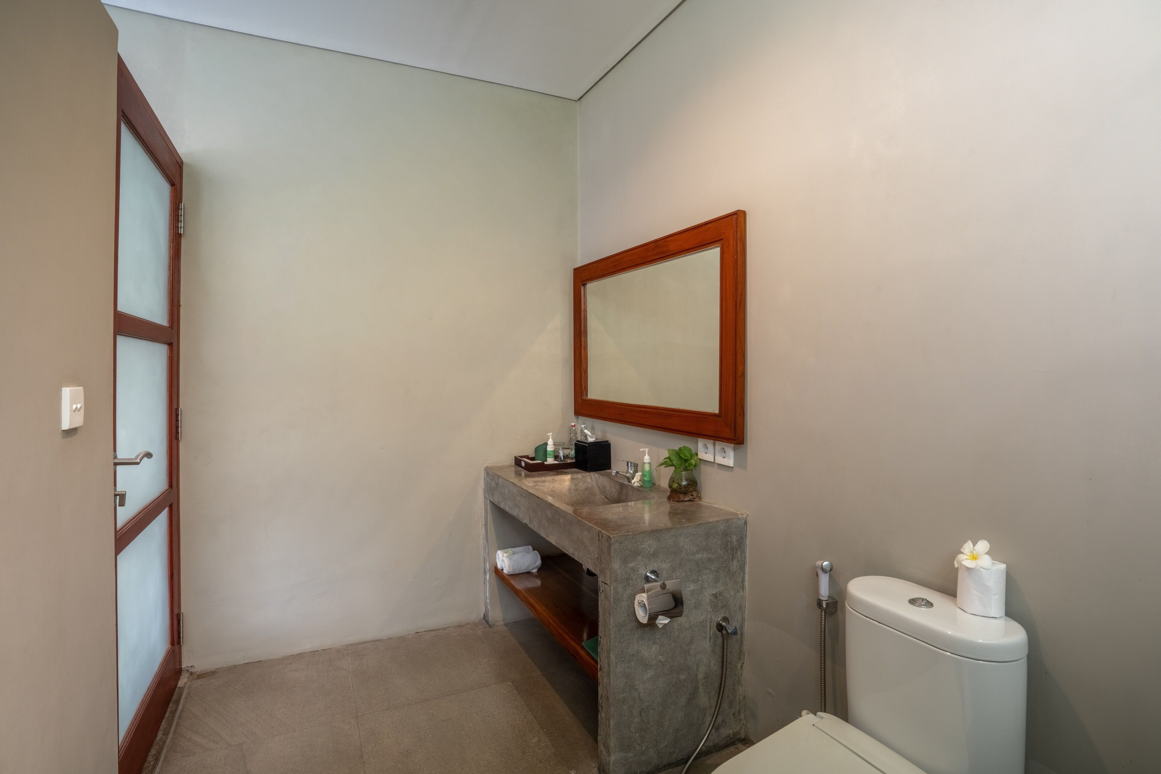 Une salle de bain équipée d’un lavabo, d’un miroir, de toilettes et d’une douche.
