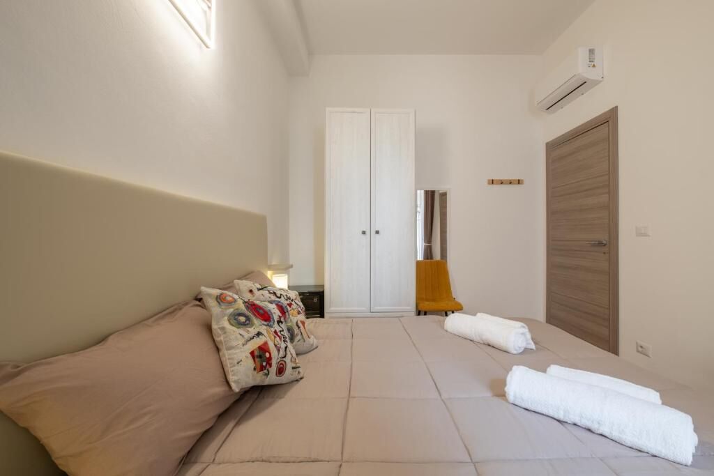 Une chambre à coucher avec un lit, une armoire, une chaise et une serviette sur le sol.