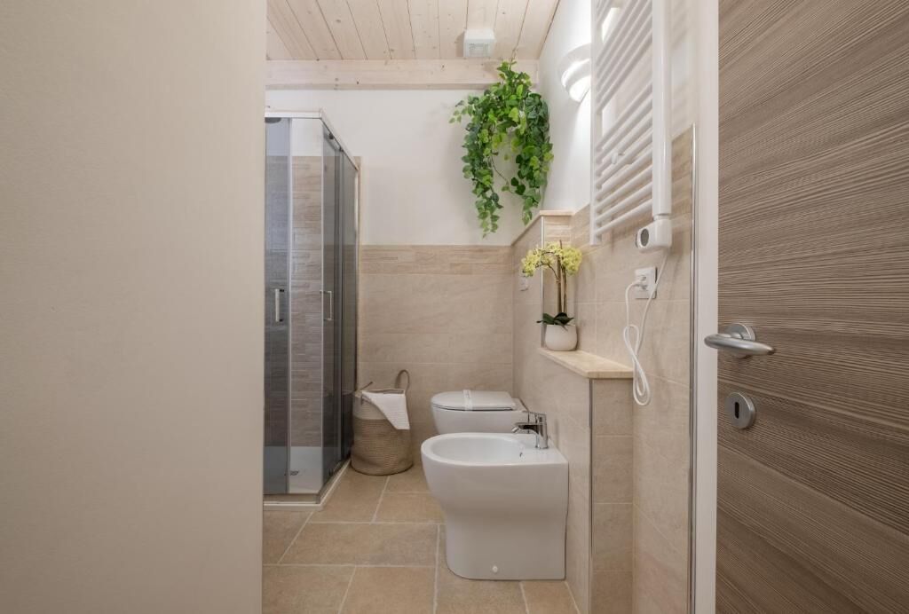 Ein modernes Badezimmer mit Dusche, Toilette, Bidet und Handtuchhalter.