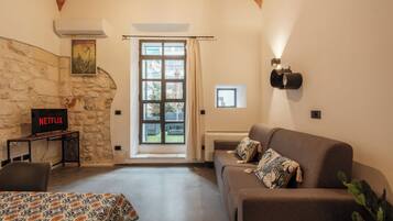 Familien-Studiosuite, Gartenblick | Wohnbereich | Fernseher