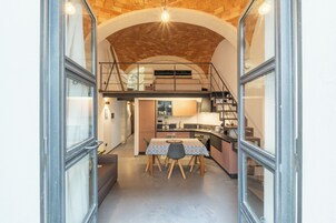 Un interior moderno con comedor, cocina y escalera.