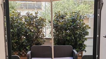 Un espace patio aménagé avec un ensemble de canapés, une table et un auvent.