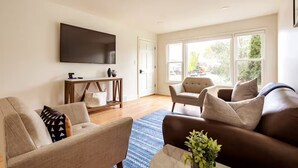 A living room with a flat-screen TV, two sofas, a coffee table, and a large window. - Top Rated w/Free Street Parking+ 2 King Beds 1 Single +In Unit-Laundry +1.5 Bath (Chicago)