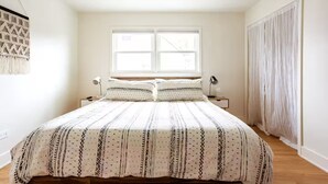 A bedroom with a large bed, two bedside tables, a window, and a curtain. - Top Rated w/Free Street Parking+ 2 King Beds 1 Single +In Unit-Laundry +1.5 Bath (Chicago)