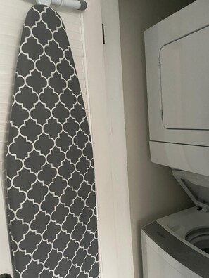 Un baño con toallero, pared blanca y lavadora.