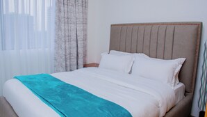 Ein Hotelzimmer mit Bett, Vorhängen und einem Fenster.