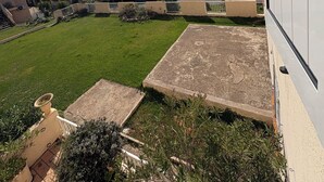 A residential area with a view of distant mountains, a green lawn, and a paved patio area. - PROMO - Sea & mountain view - 6p - parking - Linen included (Corbara)