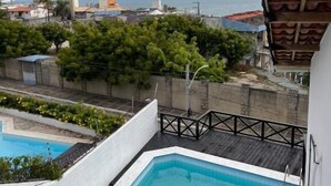 A rooftop pool with a view of the sea and surrounding buildings. - BREEZE HOTEL (Natal)