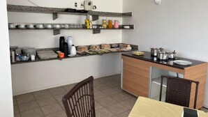 A kitchen with shelves holding dishes, a coffee maker, and a counter with a sink and utensils. - BREEZE HOTEL (Natal)