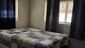 A bedroom with a bed, two windows with curtains, a ceiling fan, and a window with blinds. - Serene 3-bedroom house with AC, on-site laundry in welcoming Arlington (Arlington)