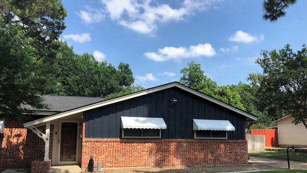 A single-story building with a brick facade, a front door, and two awnings over windows. - Serene 3-bedroom house with AC, on-site laundry in welcoming Arlington (Arlington)