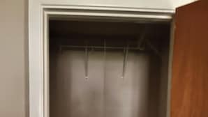 A closet with a wooden door, a white interior, and a metal shelf. - Serene 3-bedroom house with AC, on-site laundry in welcoming Arlington (Arlington)