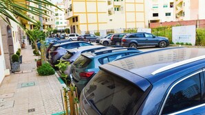 A parking lot with multiple cars, a building with balconies, and a signboard. - Dream apartment tanger (Tanger)