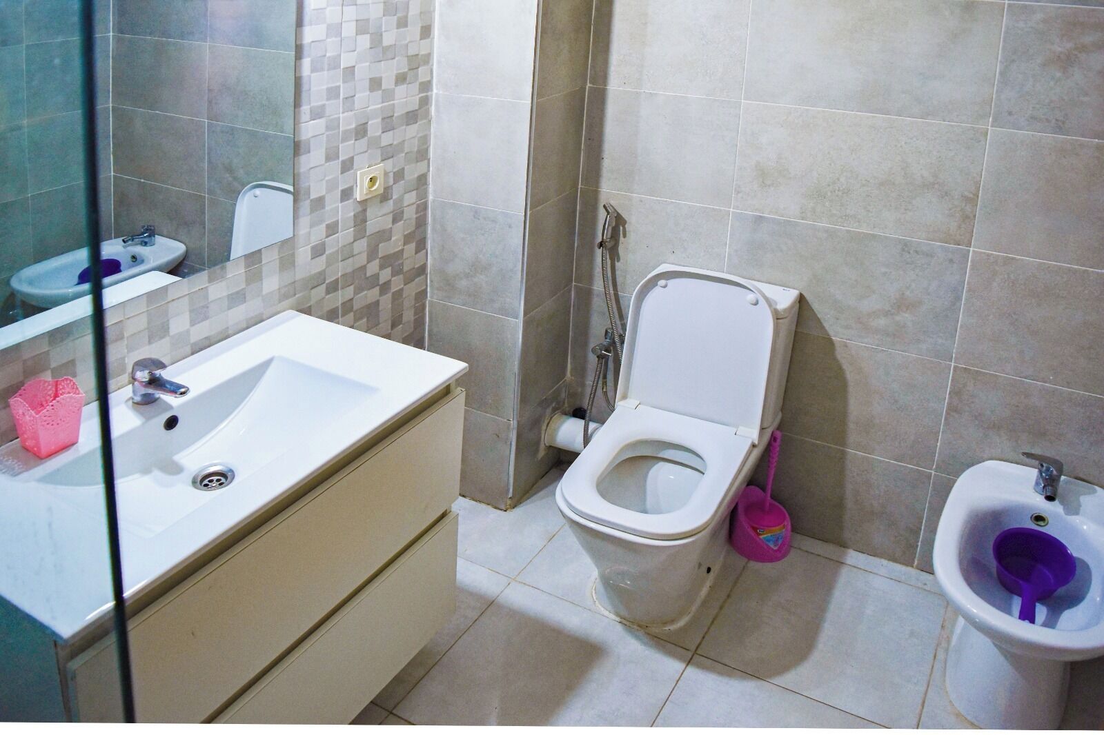 Une salle de bain équipée d’un lavabo, de toilettes, d’un bidet et d’un espace douche.