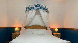 Un lit à baldaquin, deux lampes de chevet et une tête de lit en bois.