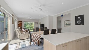 Una cocina moderna con comedor, ventanas amplias y un ventilador de techo.