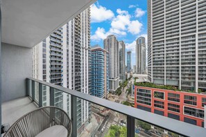 A high-rise building with multiple floors, large windows, and a view of the cityscape. - FIFA Fan Fest Walk 10min | 1BR+Den | Pool / Grill (Miami)