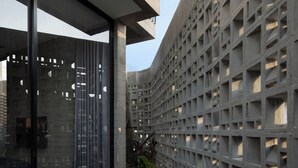 A modern building with large windows, a concrete facade, and a geometric pattern. - Orama Bali (Pecatu)