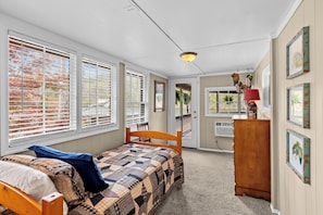 A bedroom with a bed, a dresser, a chair, and a door leading to a balcony. - Welcome to Water's Edge! Clanton, AL (Clanton)