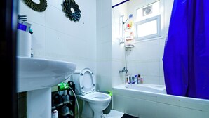 Une salle de bain comprenant des toilettes, un lavabo, une douche et une baignoire.