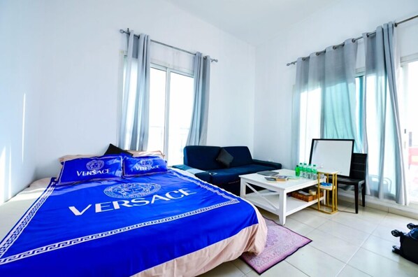 Une chambre d’hôtel équipée d’un lit, d’un canapé, d’un bureau et d’un tableau blanc.
