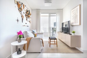Uma sala de estar moderna com sofá, TV e uma obra de arte com mapa-múndi.