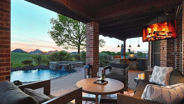 A covered outdoor seating area with a pool, a fire feature, and a television. - 4BR Frisco Escape / Pool + Theater / Sleeps 10 / Spacious (Frisco)