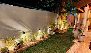 A well-lit outdoor garden area with various potted plants and a stone pathway.