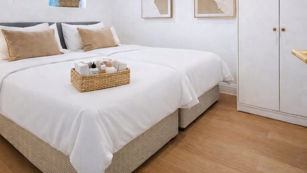 A bedroom with a bed, pillows, a bedside table with a basket, and two framed artworks on the wall. - Dettori 2BR With Garden 11 Mins Walk to Gallops (Newmarket)