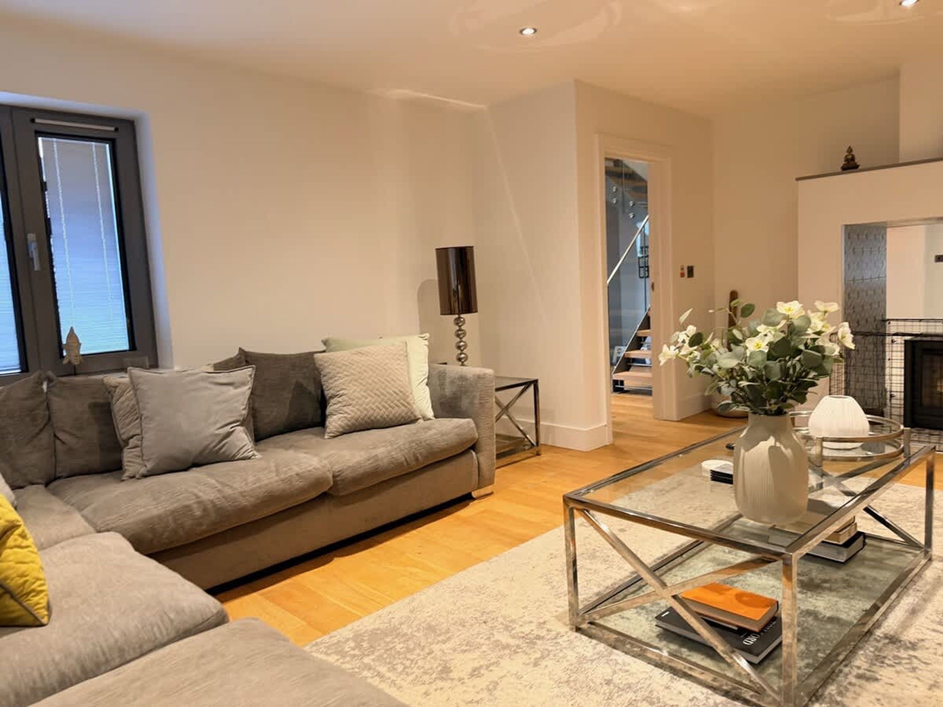 A modern living room with a sofa, coffee table, and a fireplace.