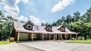 A two-story house with a garage, a covered porch, and a well-maintained lawn.