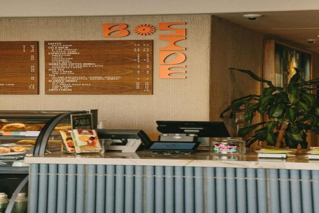 Un comptoir de café avec un tableau affichant le menu, une carte de fidélité et une plante.