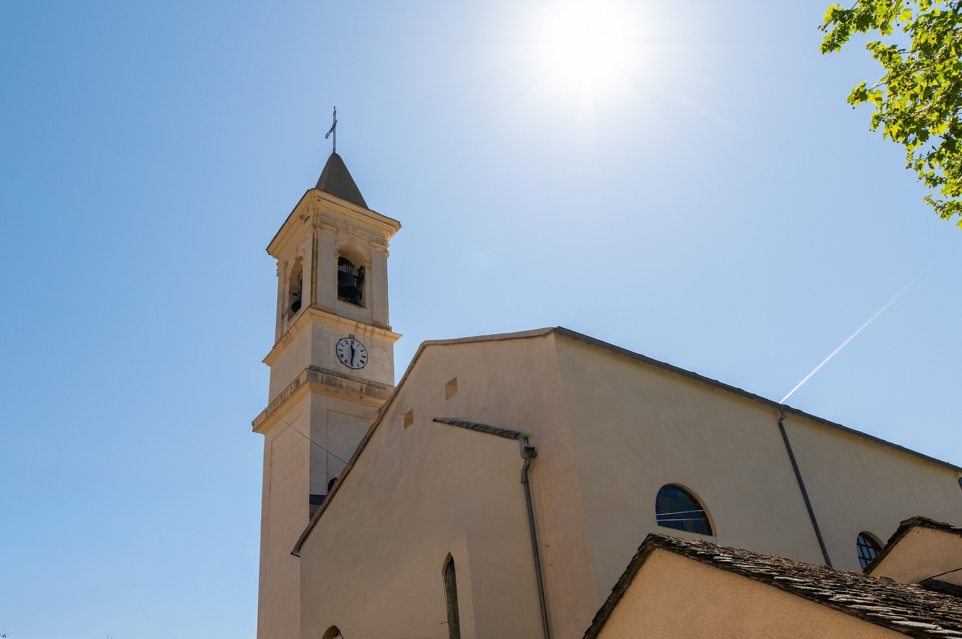 Església amb un campanar i un rellotge, sota un cel serè.