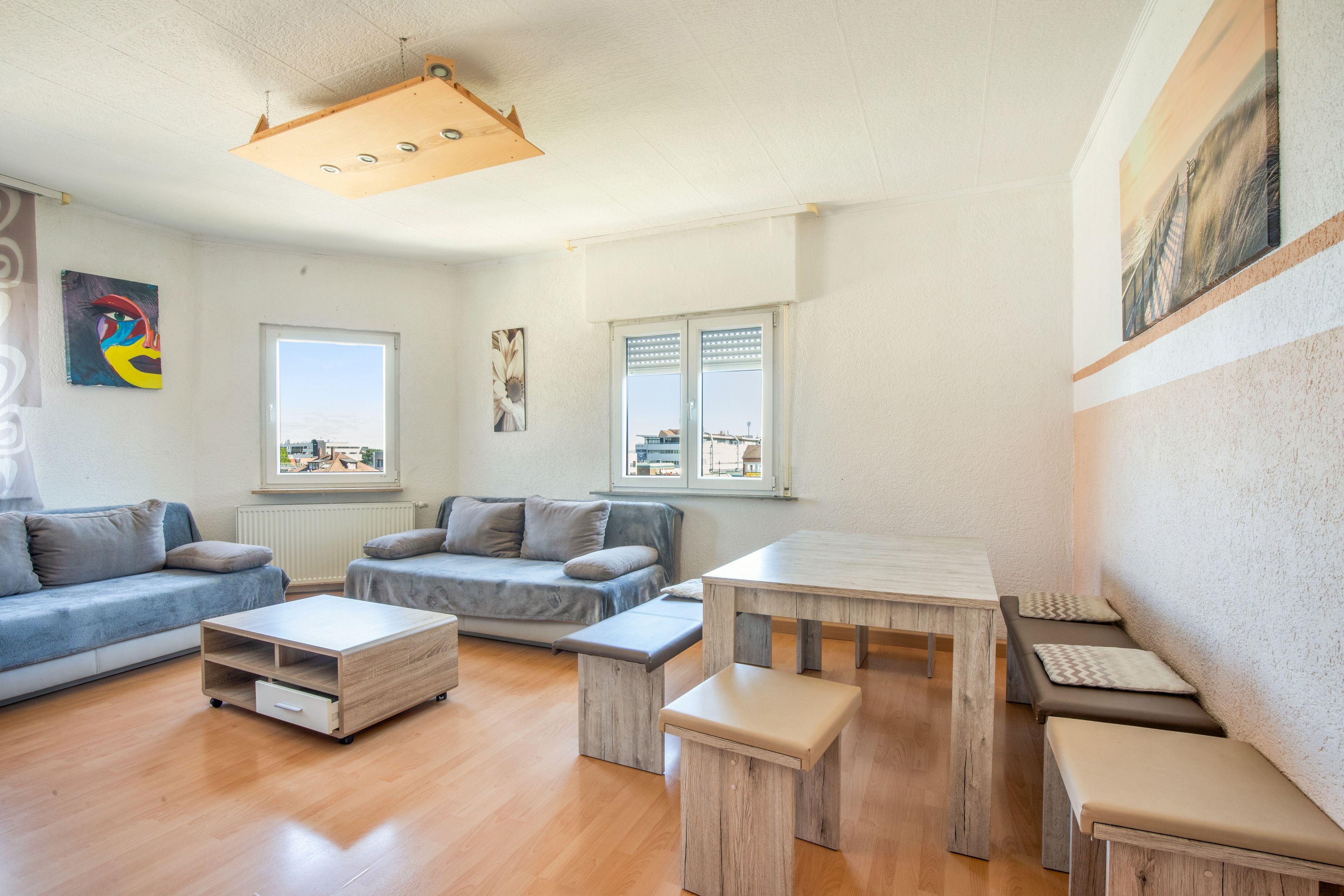 Un salon moderne avec un canapé, une table basse et une petite table.