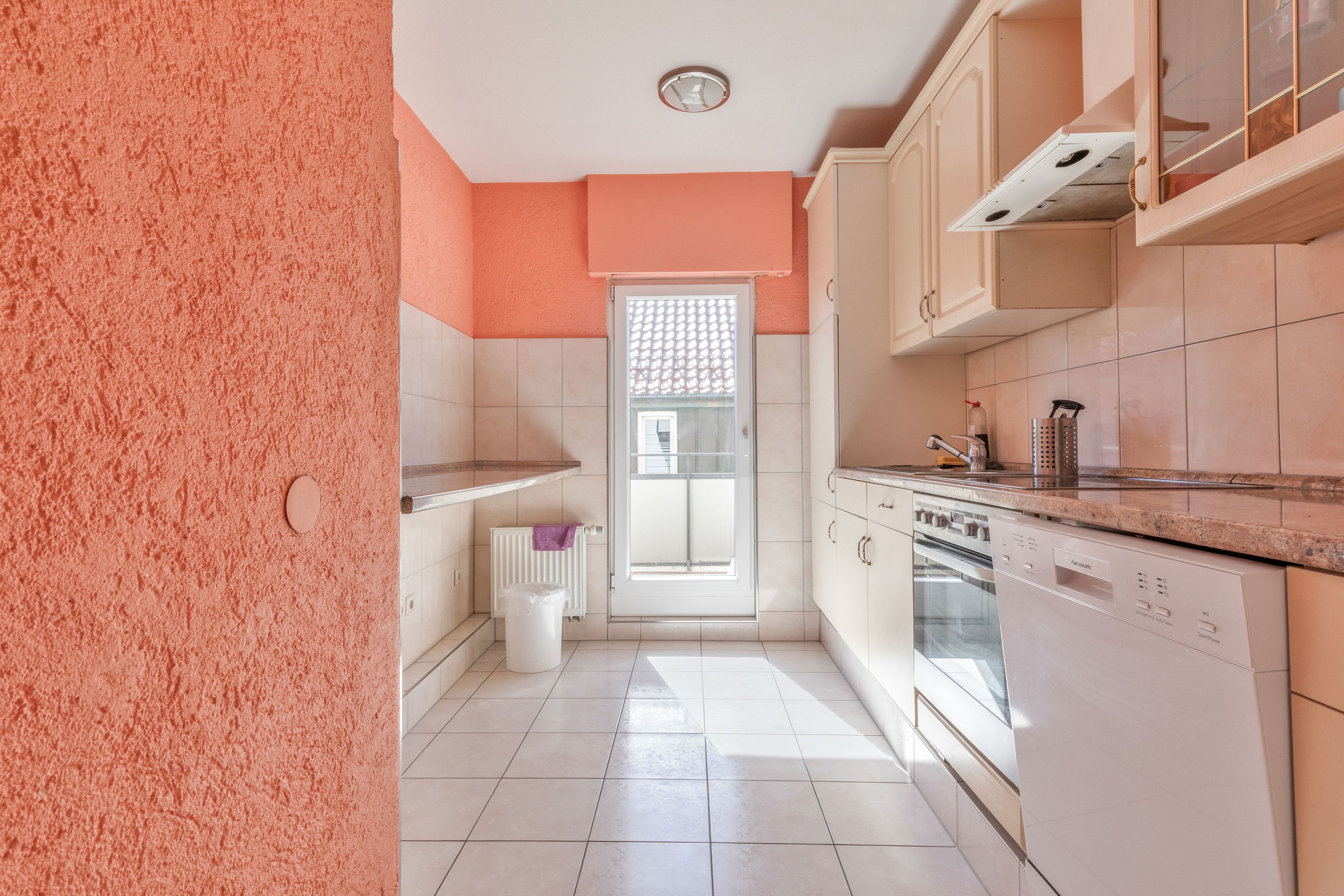 Una cucina con mobili bianchi, una lavastoviglie e una finestra vista panoramica.