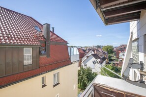 A residential building with a red-tiled roof, a chimney, and a window with a metal railing. - Stylish Apartment in Fellbach with Balcony and Wi-Fi (Fellbach)