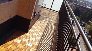 A balcony with a tiled floor, metal railing, and a view of a cityscape with buildings and mountains in the distance. - Lilly's house (Avellino)
