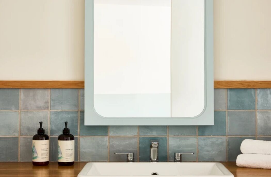 A bathroom with a white sink, two bottles of liquid soap, and a towel on the counter.