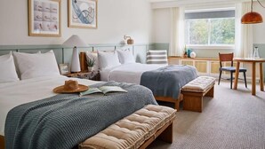 A hotel room with two beds, a dining table, a bench, and a window with a view. - Wayfinder Newport | 2 Units | Premium 2 Queens | Local Art Scene (Newport County)