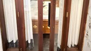 A room with a bed, a television, and a window with curtains. - Peaceful 3BR Villa | Fast Starlink WiFi | Walk to Beach (Ahangama)