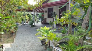 A covered outdoor area with potted plants and a gravel path. - Peaceful 3BR Villa | Fast Starlink WiFi | Walk to Beach (Ahangama)