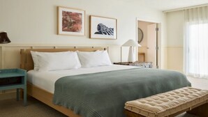 A neatly arranged hotel room with a bed, bedside tables, a bench, and framed artwork on the wall. - Wayfinder Suite | Wayfinder Newport | Newport Unfiltered, Mural Pool | 2 Units (Newport County)