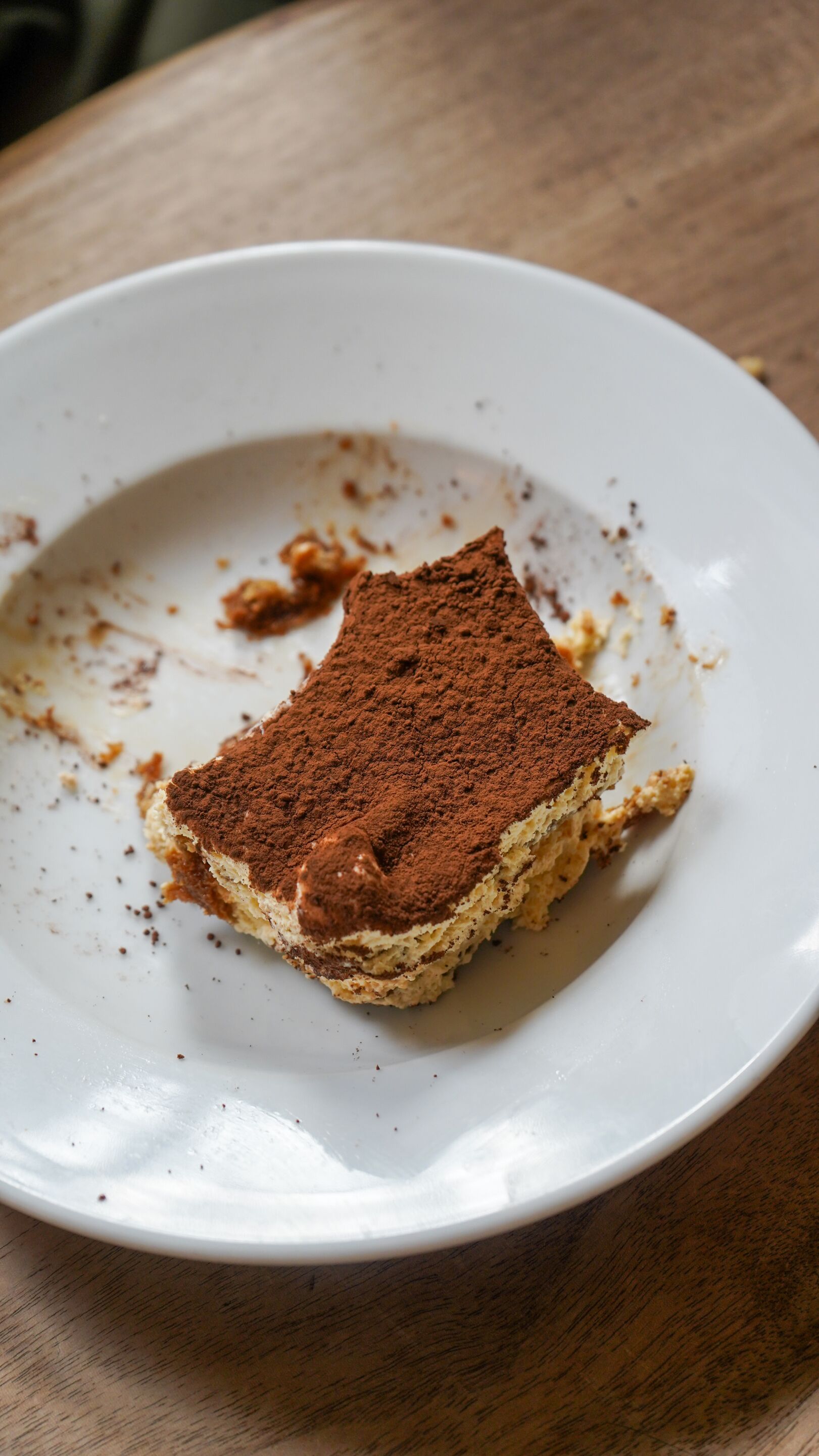 A slice of tiramisu on a white plate.