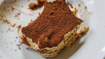 A slice of tiramisu on a white plate.