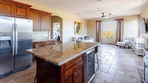A modern kitchen with granite countertops, stainless steel appliances, and a dining area with a view. - Ranch Road Desert Oasis...Privacy...Unbelievable Mountain Views! (Scottsdale)