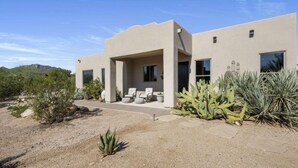 A modern house with a patio, large windows, and desert landscaping. - Ranch Road Desert Oasis...Privacy...Unbelievable Mountain Views! (Scottsdale)