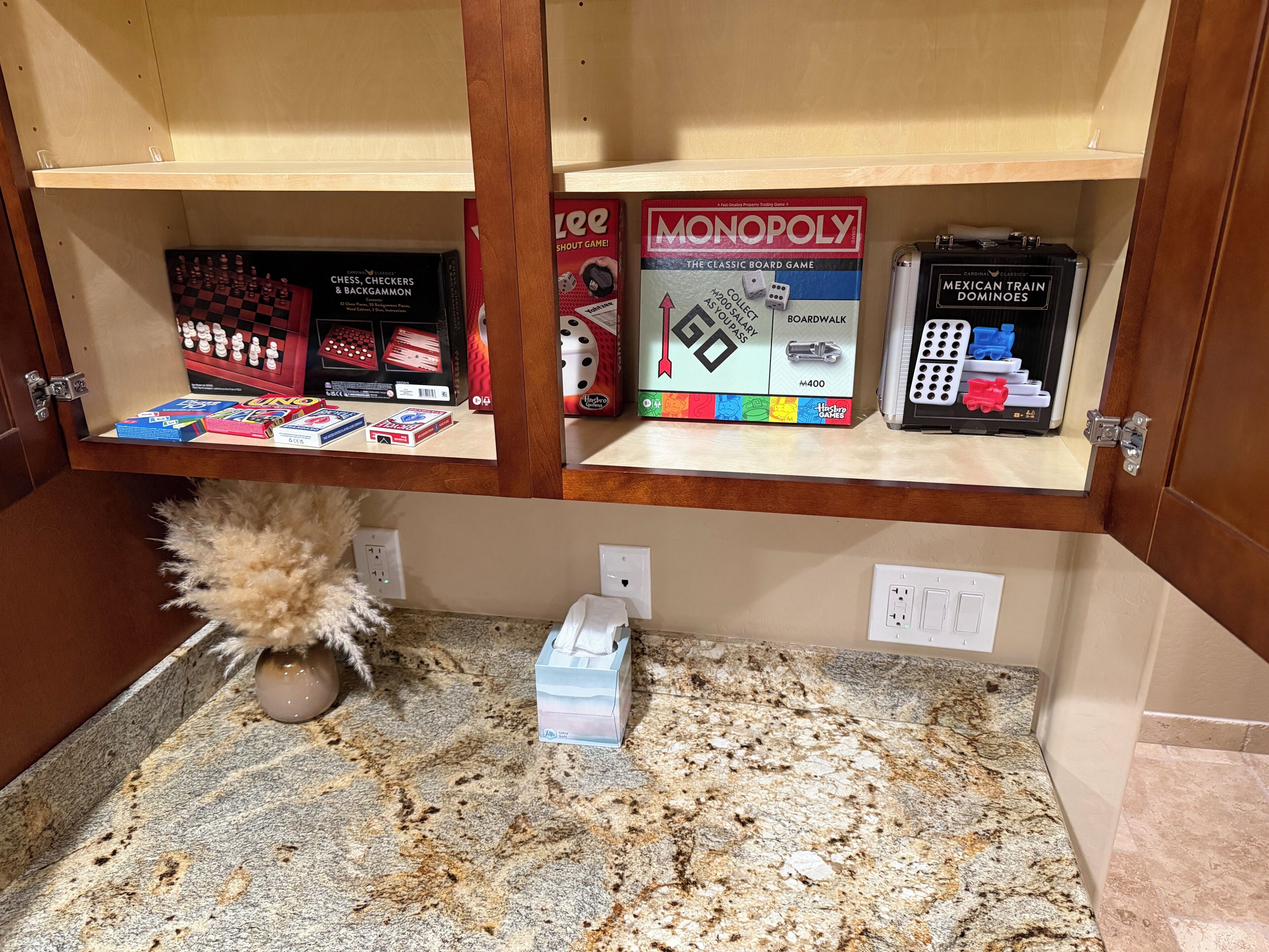 Un estante con juegos de mesa, incluyendo Monopoly y ajedrez.