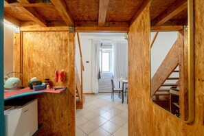 Ein Holzinnenraum mit Küchenzeile, Esstisch und Treppe.