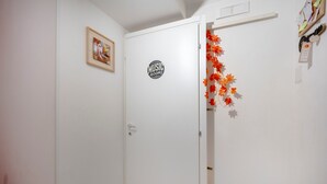 En vit dörr med en skylt som säger ”MUSIKRUM”, en inramad tavla på väggen och höstlövsdekorationer.