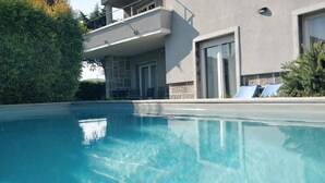 A modern building with a swimming pool, a balcony, and a door. - Casa Jasmim - Tranquil Refuge (Algueirão-Mem Martins)
